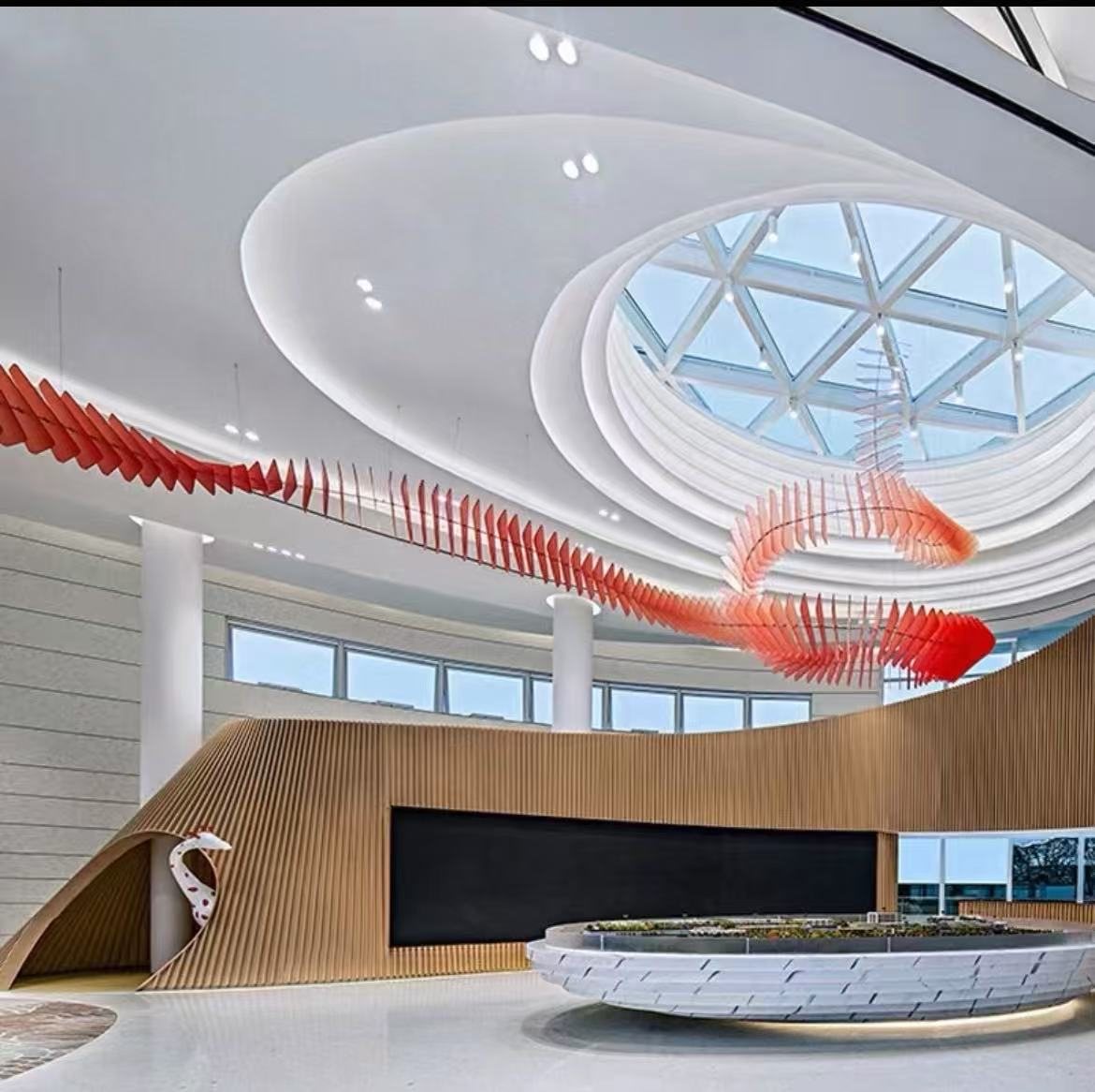 Sweeping red acrylic ribbon ceiling feature over an atrium