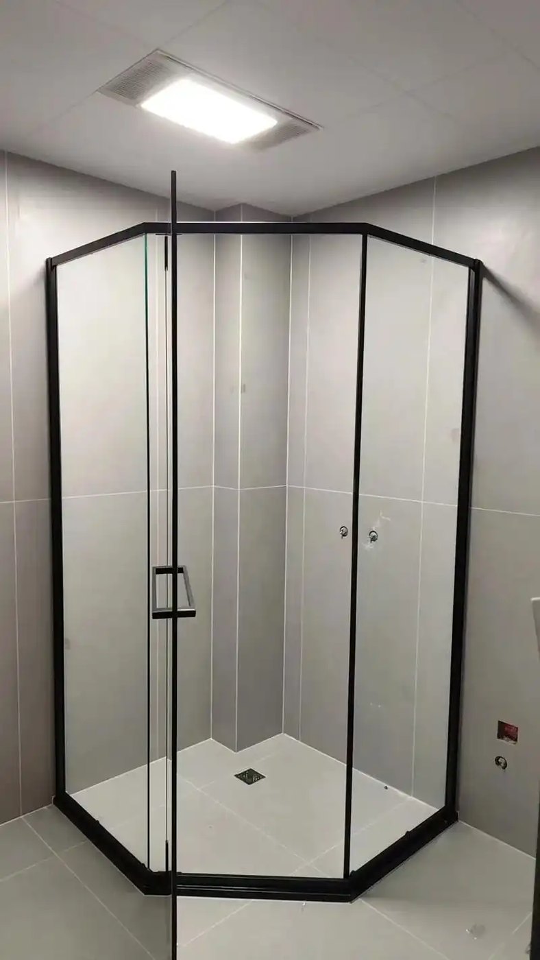 Corner shower enclosure built from clear acrylic panels in a black frame