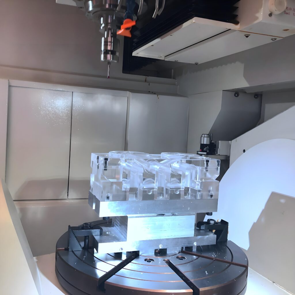 5-axis CNC machining center cutting a clear custom acrylic part